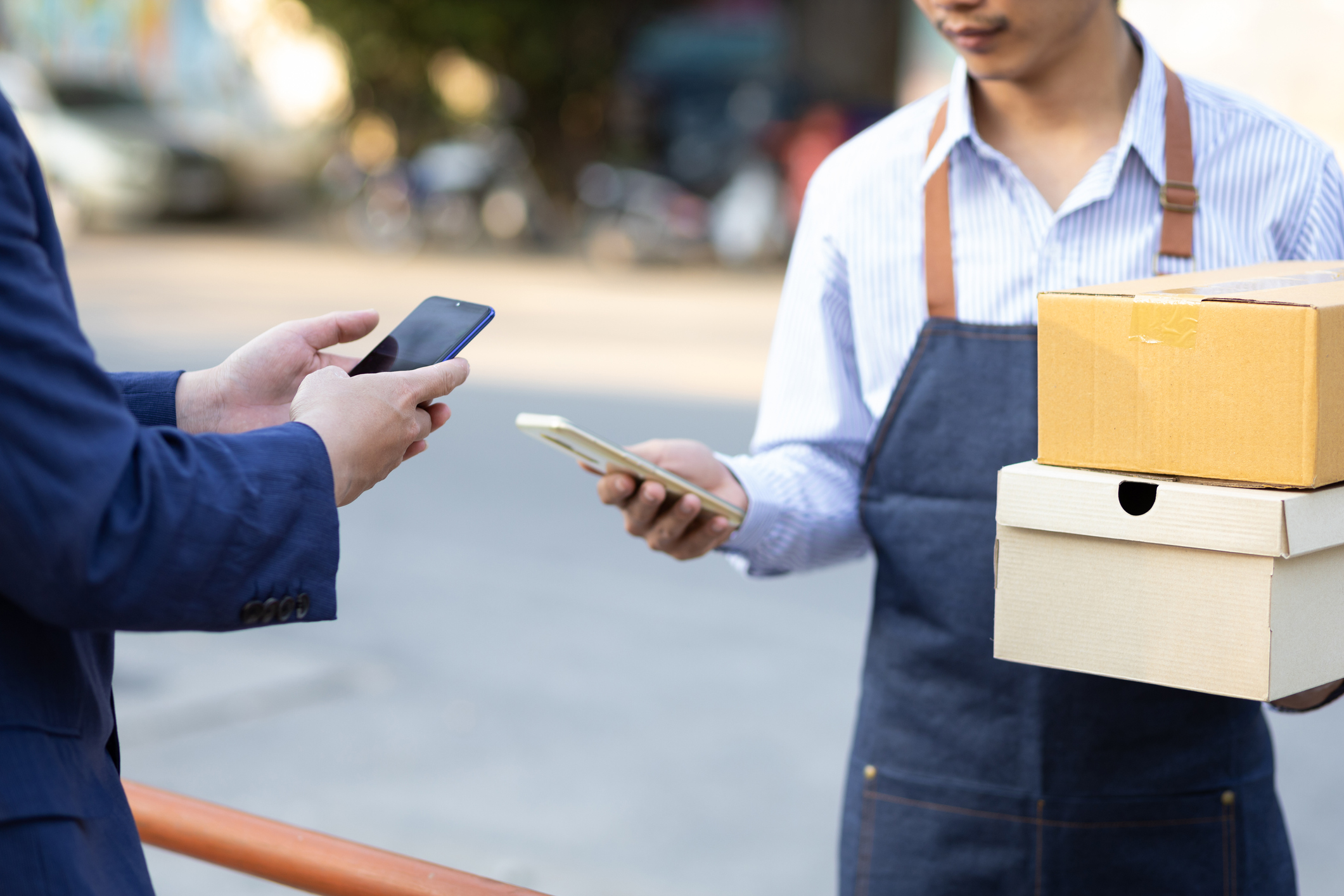 Man bezahlt einen Boten für eine Essenslieferung mit dem Smartphone