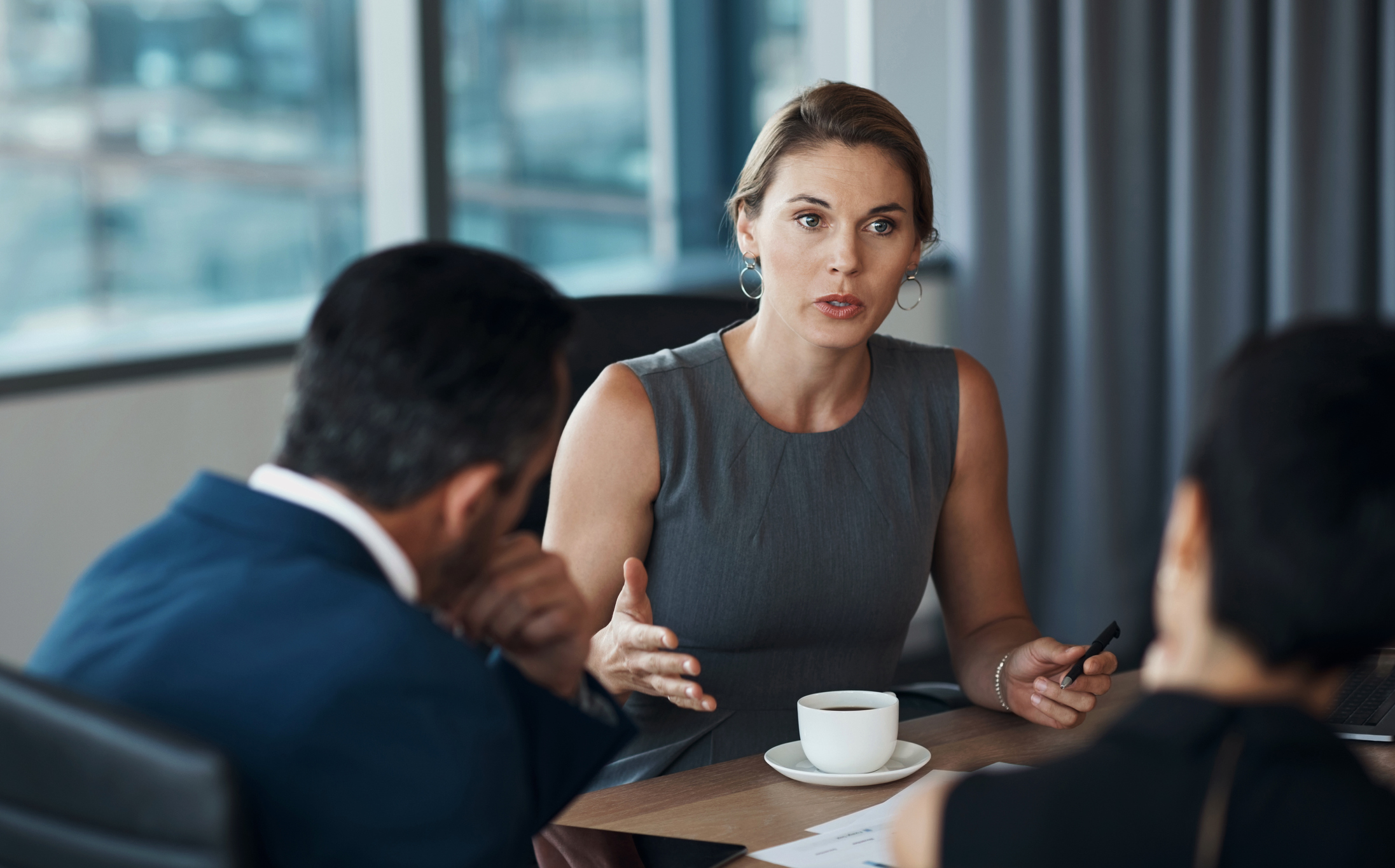 Ernsthafte Frau, die mit Geschäftskunden spricht, wenn es um Besprechungsverhandlungen, Rechtsberatung oder professionelle Beratungsplanung geht. Anwalt, Manager oder Unternehmensvertreter im Konferenzraum diskutieren über Karrierestrategie.