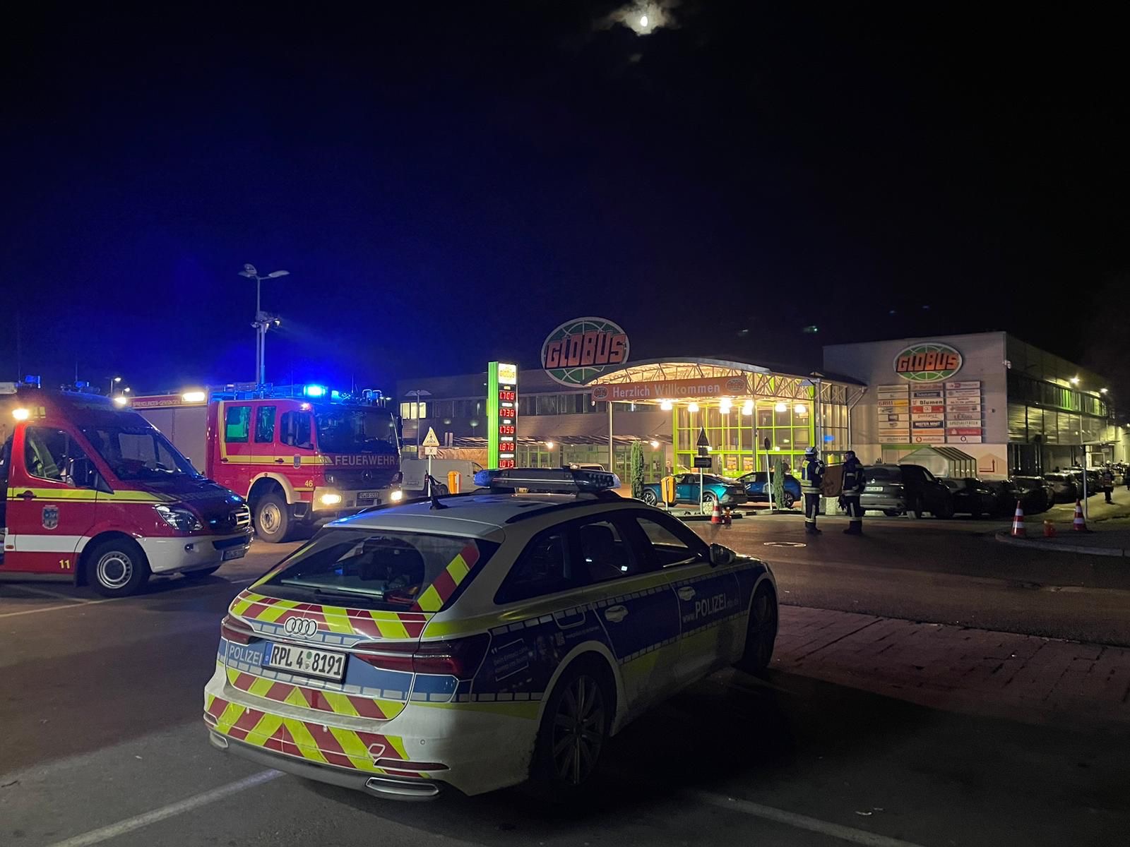 Das Foto zeigt ein Polizeiauto bei Nacht vor einem Supermarkt, in dem ein geldautomat gesprengt wurde.